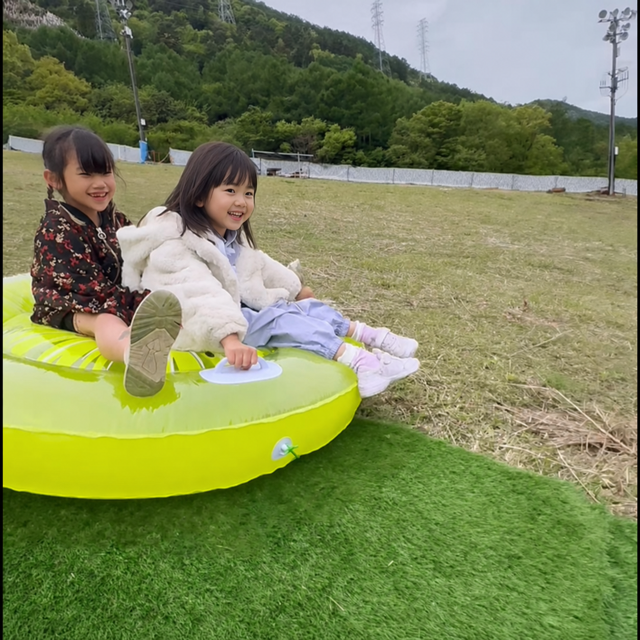 親子で芝そりを楽しむ様子